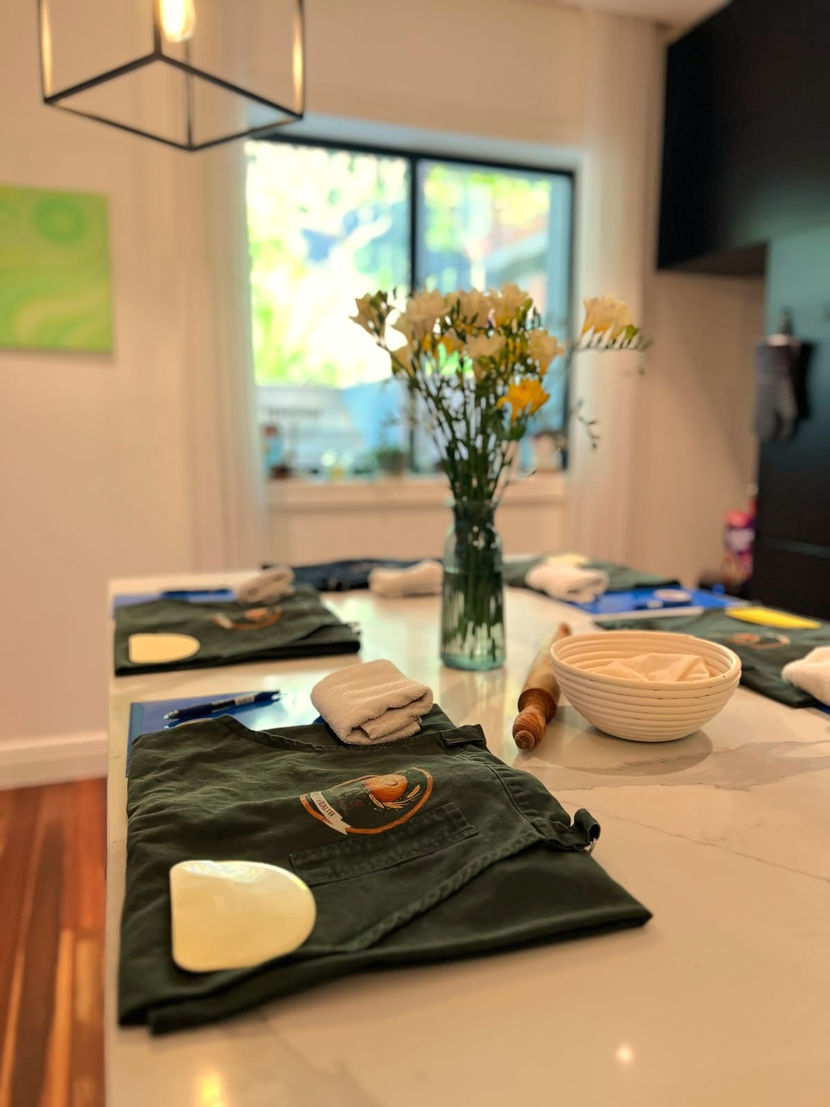 Workshop aprons and fresh flowers set out ready for a baking class