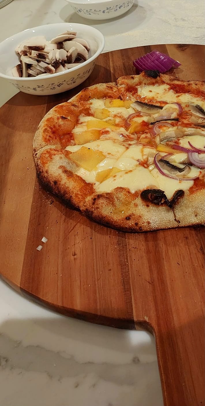 Finished homemade pizza with melted cheese, onion and mushroom